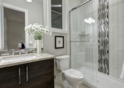 Beautiful bathroom in new luxury home with a mixed tile splash in shower