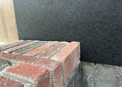 detail black stone hearth meeting brick fireplace lakeland shores