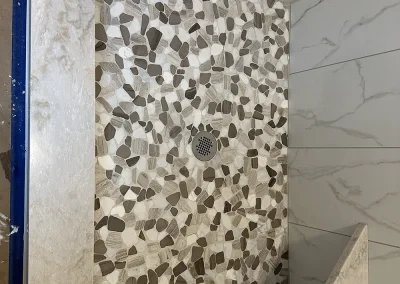 pebble mosaic shower floor and stone bench
