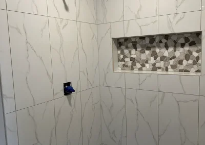 white marble look shower wall and niche